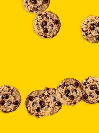 Sunny yellow paper with chocolate chip cookies. sweet biscuits. Homemade pastries. Food background with place for text.の写真素材