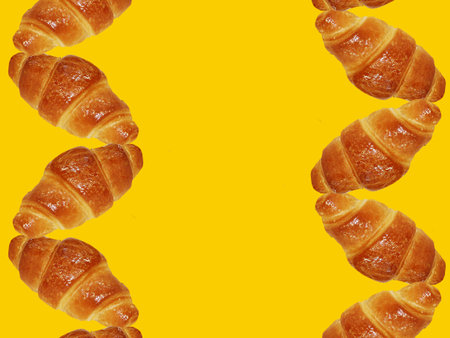 Mini French croissants on a yellow paper background. Traditional fresh bread. Space for text or advertising slogan.の写真素材