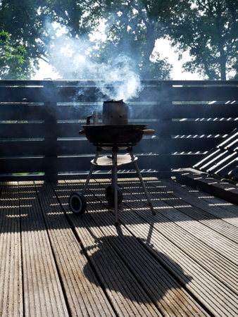 The grill grate in subtle smoke. A summer day on the terrace.の写真素材