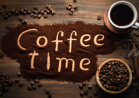 Wooden background with coffee beans and powder from ground coffee forming the words "coffee time".の写真素材