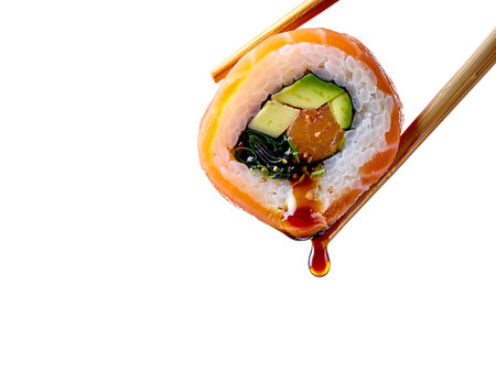 A pair of chopsticks lifts a colorful sushi roll, highlighting its fresh ingredients and artistic arrangement. Vivid colors and intricate presentation. Cut from the background.の写真素材