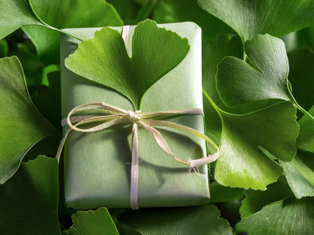 A present wrapped in vibrant green leaves, placed gently on the ground, blending with the surrounding nature.の写真素材