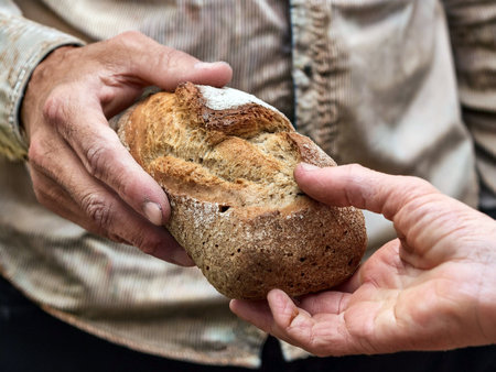 A young man hands over a loaf of bread to a hungry man in need showing support and humanitarian aid...