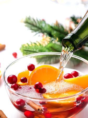 A bottle of wine pours into a bowl filled with assorted fruits and aromatic spices, creating a vibrant and inviting scene.の写真素材