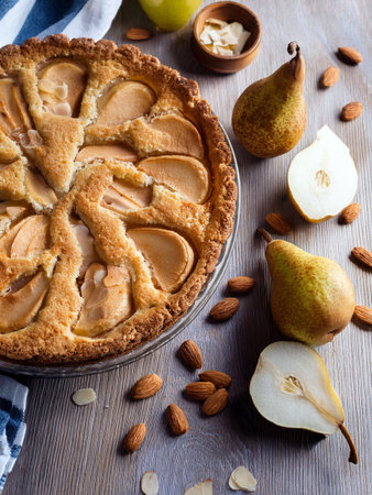 Crostata pear, almond and amaretti on a rustic wooden table. Perfect dessert with a golden-brown crust, ideal for fall baking inspiration.の写真素材