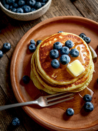 Pancakes with blueberries, butter and honey. Sweet breakfast or brunch meal.の写真素材