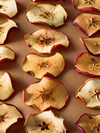 Dried apple slices arranged on a surface, showing a healthy snack option rich in fiber and nutrients.の写真素材