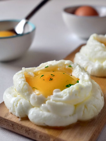 Baked fluffy cloud eggs delicious any time of the day, white tones, food photography.の写真素材