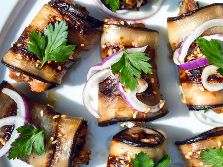 Georgian eggplant rolls filled with walnuts, garlic and spices, garnished with fresh cilantro and pickled red onions on a white plate. A vegetarian appetizer.の写真素材