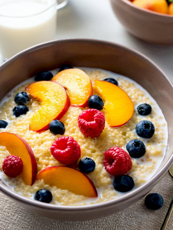 Buckwheat cooked with milk served in a ceramic bowl with fruit. A healthy breakfast.の写真素材