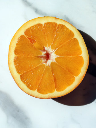 Sliced orange on marble surface, showing juicy segments and vibrant color, perfect for healthy eating and vitamin C boost.の写真素材