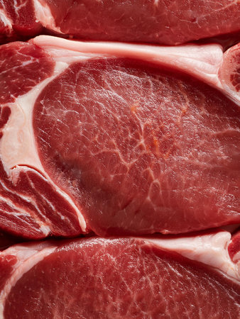 Close-up of fresh, uncooked beef slices arranged in layers, showing the rich red color and marbled texture. Perfect for barbecue, grilling, or gourmet recipes.の写真素材