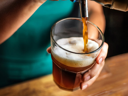 The barista in the process of pouring the cold nitro brew into the glass. Alternative methods of...
