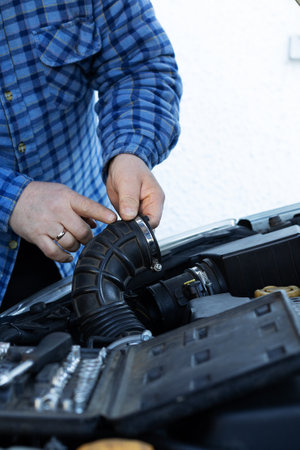 Mans Hands Using Tools to Repair a Car Engine Beneath the Open Hood, Mechanical Expertise in...