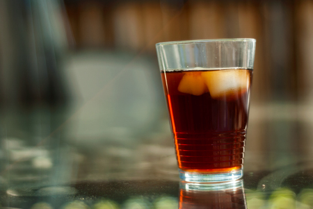 A glass of refreshing iced tea sits on a table on a patio in summertime.の写真素材