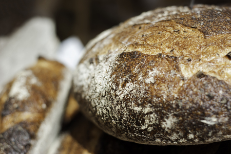 A close up of a loaf of bread sitting in a stack at a farmer's market.の写真素材