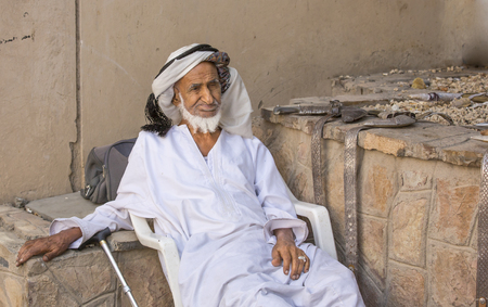 Nizwa, Oma, 24th March, 2017: old Omani man selling old copper cooking dishes at the marketのeditorial素材
