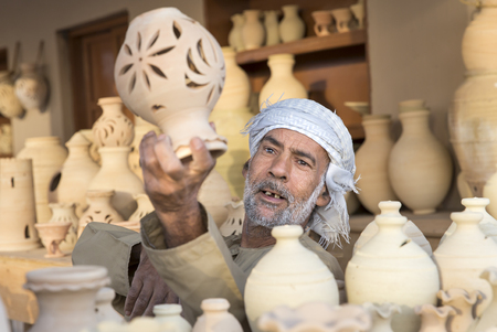 Muscat, Oman, February 4th, 2017: omani man selling clay jarsのeditorial素材