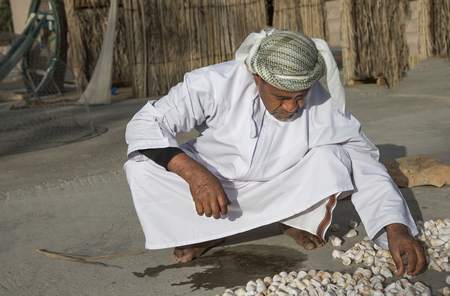 Muscat, Oman, February 4th, 2017: old fisherman playing with sea chellesのeditorial素材