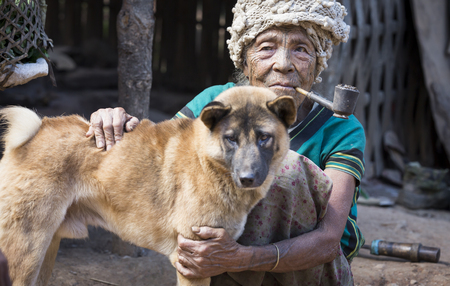 Chin region, Myanmar, November 11, 2014: muun tribe chin lady with her dogのeditorial素材