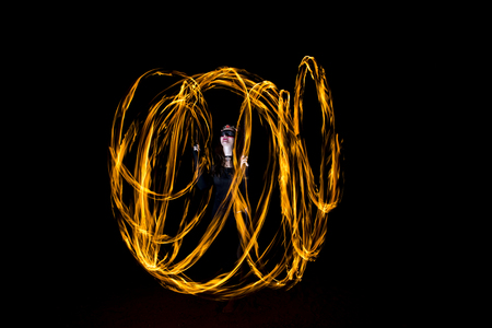 young woman dancing with fire poi, making cirlesの写真素材