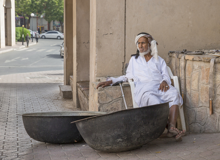 Nizwa, Oman, 24th March, 2017: old Omani man selling old copper cooking dishes at the marketのeditorial素材