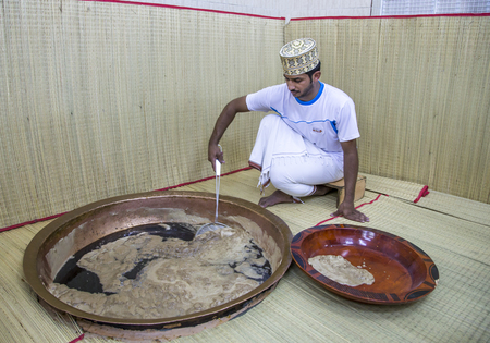 Nizwa, Oman, 26th May, 2016: worker at a halwa factory mixing a pot of halwaのeditorial素材