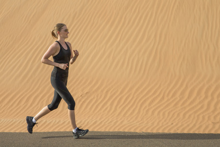 woman running on a road in a desertの写真素材