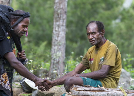 Baliem Valley, West Papua, Indonesia, February 12th, 2016: Hiker meeting a local man in Baliem Valleyのeditorial素材