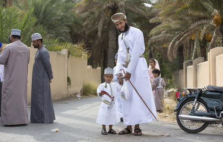 Nizwa, Oman - June 26th 2017: family in traditional clothing at a toy market on a day of Eid al Fitr, celebration at the end of Holy Month of Ramadanのeditorial素材