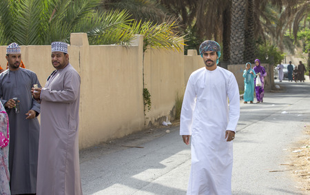 Nizwa, Oman - June 26th 2017: omani people in traditional clothing at a toy market on a day of Eid al Fitr, celebration at the end of Holy Month of Ramadanのeditorial素材