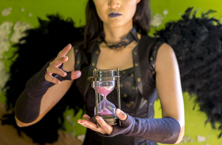 young woman inside of an abandoned house with an hour clock running down the timeの写真素材