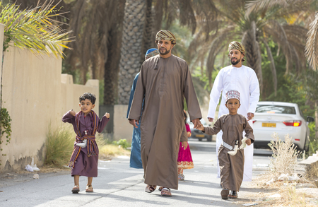 Nizwa, Oman - June 26th 2017: family  in traditional clothing at a toy market on a day of Eid al Fitr, celebration at the end of Holy Month of Ramadanのeditorial素材
