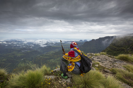 Gondar, Ethiopia, October 4th, 2014: Mountain ranger with a gun resting and overlooking a valley in Simien Mountainsのeditorial素材
