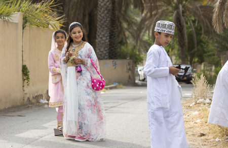 Nizwa, Oman - June 26th 2017: young ladies in traditional clothing at a toy market on a day of Eid al Fitr, celebration at the end of Holy Month of Ramadanのeditorial素材
