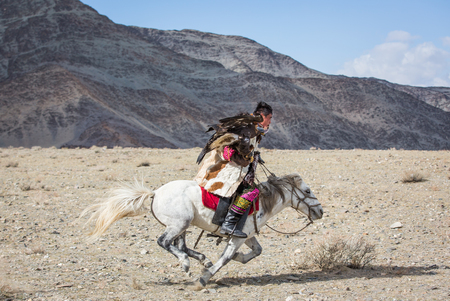 BAYAN ULGII, MONGOLIA - CIRCA OCTOBER 2015: Kazakh man in traditional clothing on his horse...