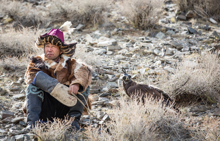 BAYAN ULGII, MONGOLIA - CIRCA OCTOBER 2015: Eagle hunter resting with his golden eagle on his arm