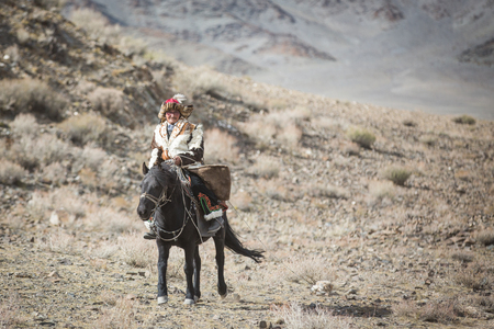 BAYAN ULGII, MONGOLIA - CIRCA OCTOBER 2015: Kazakh man in traditional clothing on his horseのeditorial素材