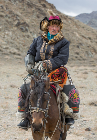 BAYAN ULGII, MONGOLIA - CIRCA OCTOBER 2015: Kazakh man in traditional clothing on his horse