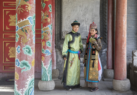 mongolian couple in traditional outfit near old Temple in Ulaanbaatarの写真素材