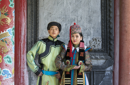 mongolian couple in traditional outfit near old Temple in Ulaanbaatarの写真素材