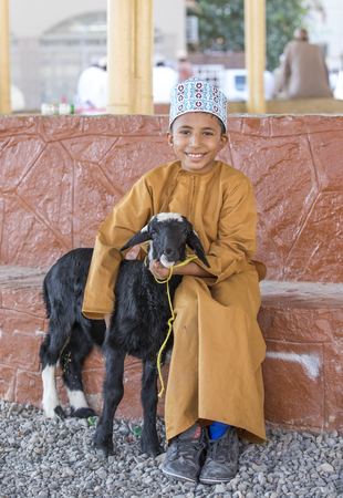 Nizwa, Oman, November 10th, 2017: omani boy with a goat at a marketのeditorial素材