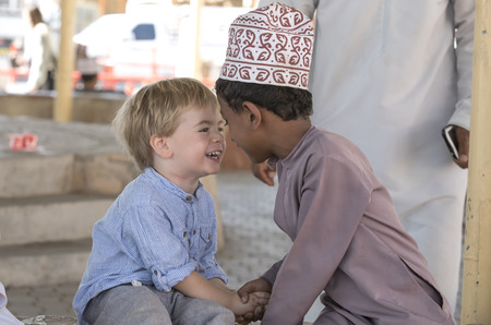 Nizwa, Oman, 10th Nobember 2017: omani kid and european kid giving eachother an eskimo kissのeditorial素材