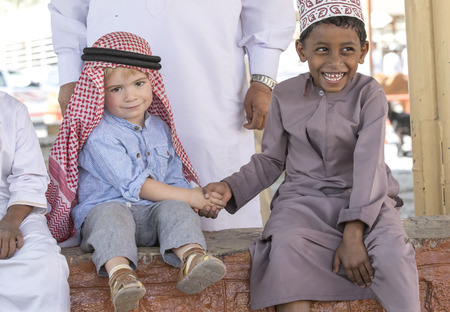 Nizwa, Oman, 10th Nobember 2017: omani kid and european kid shaking handsのeditorial素材