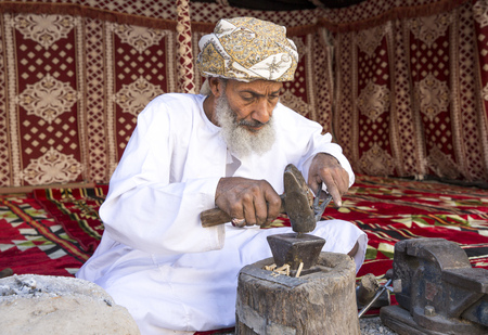 Nizwa, Oman, December 1st, 2017: omani man working with a piece of metal to make a knifeのeditorial素材