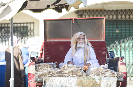 Sinaw, Oman, November 30th, 2017: bedhouin man selling dry fish at a marketのeditorial素材
