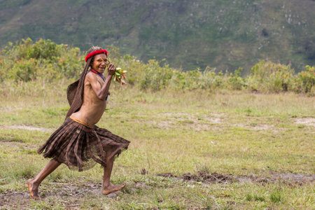 Baliem Valley, West Papua, Indonesia, February 2016: Dani tribe woman running in natureのeditorial素材