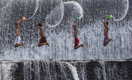 Bali, Indonesia, September 11th, 2016: Young Indonesian boys having fun at a waterfallのeditorial素材