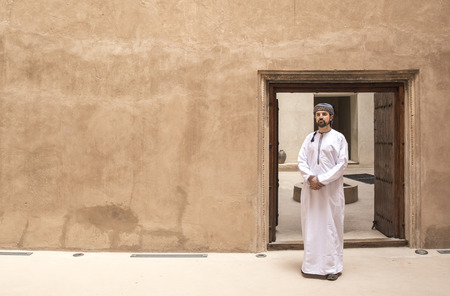 arab man in traditiona omani outfit standing inside old omani houseの写真素材