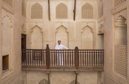 Omani man in traditional clothing in a courtyard restingの写真素材